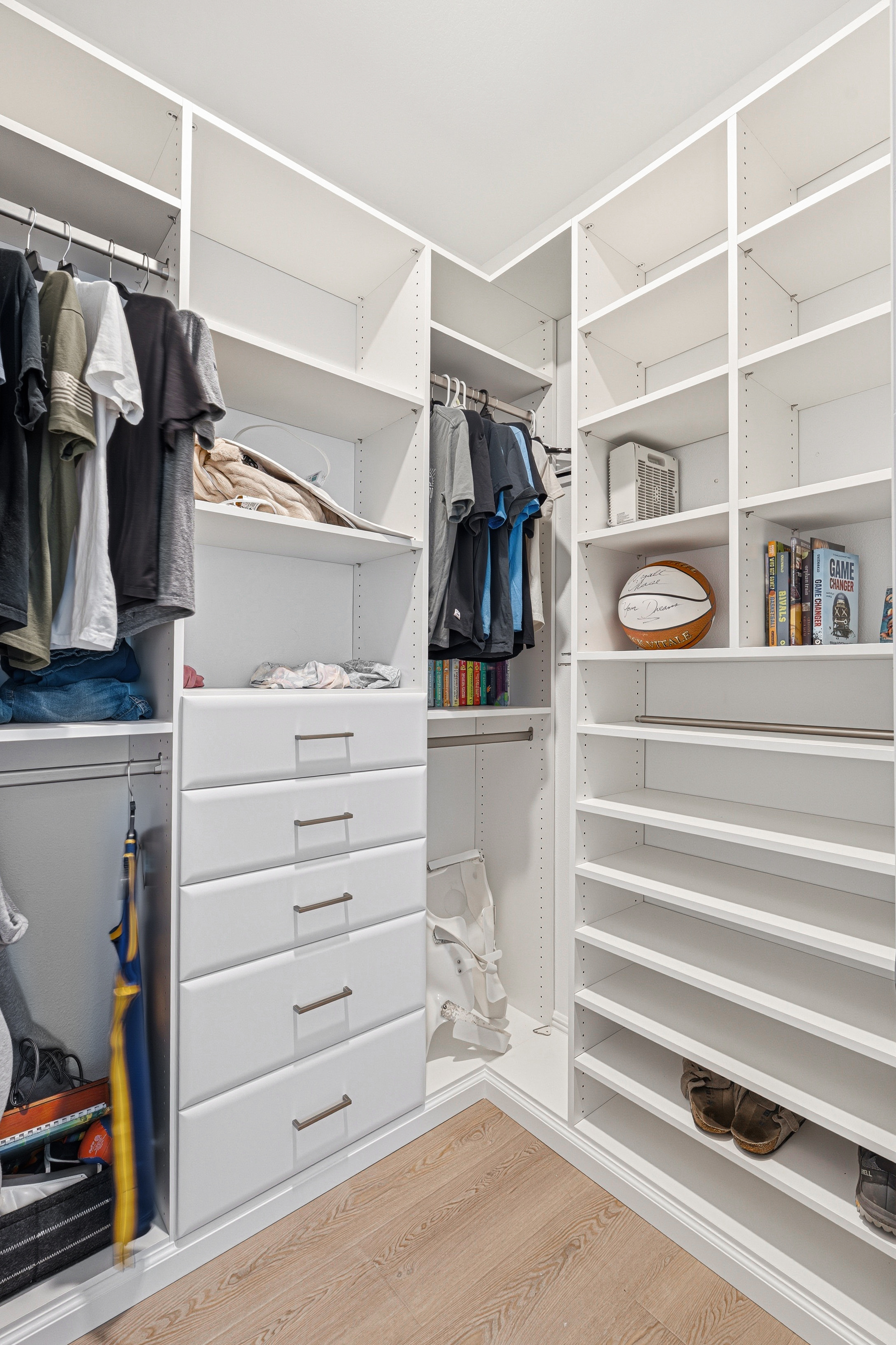 Corner walk-in closet with open shelving, shoe storage, and hanging zones in Bradenton FL