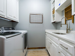 Custom laundry room cabinetry with white cabinets and countertop