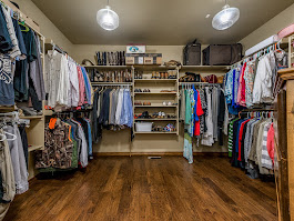 Organized walk-in closet with clothes, shoes, and accessories displayed