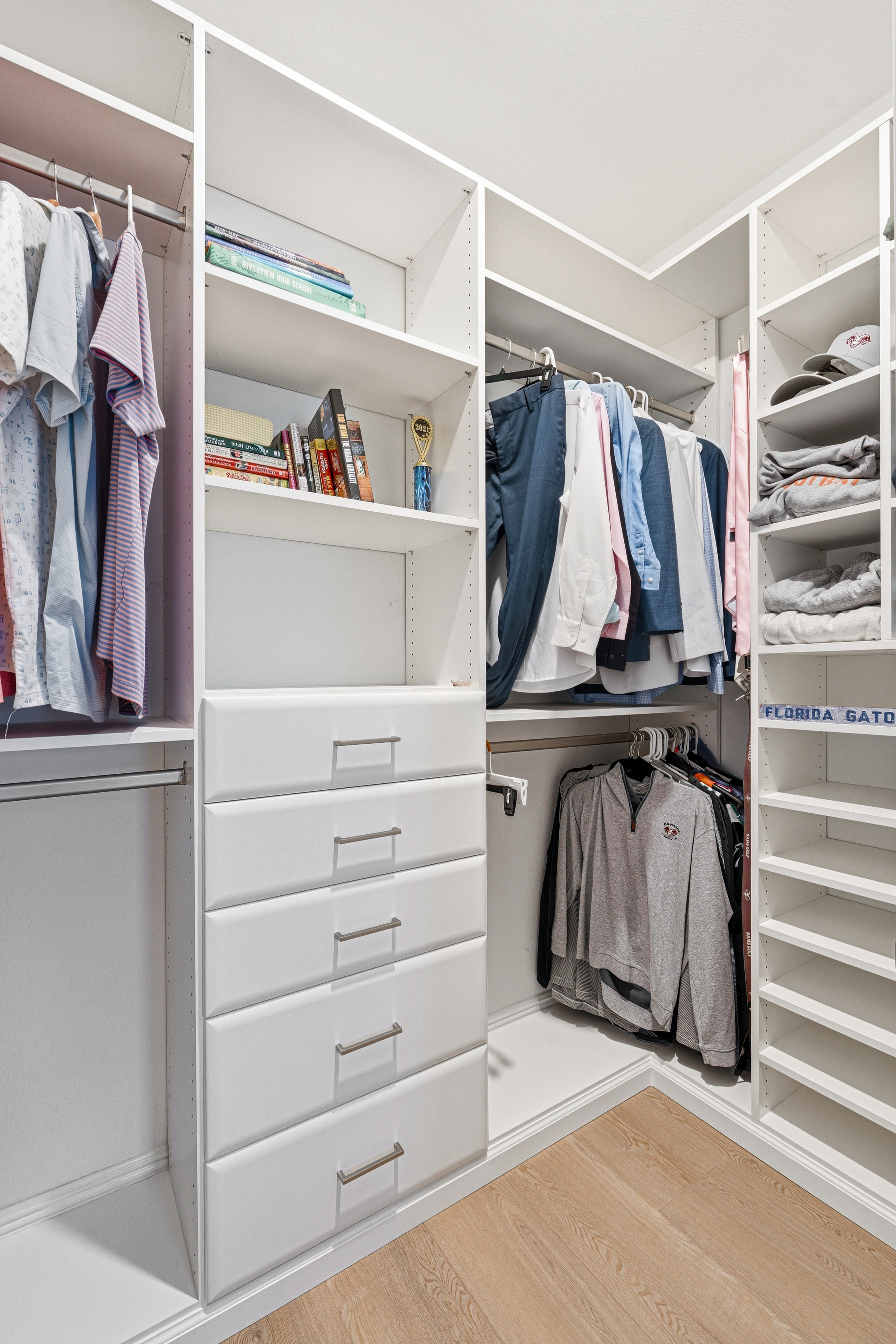 Reach-in closet with dual hanging rods, center drawer tower, and open shelving in Bradenton FL