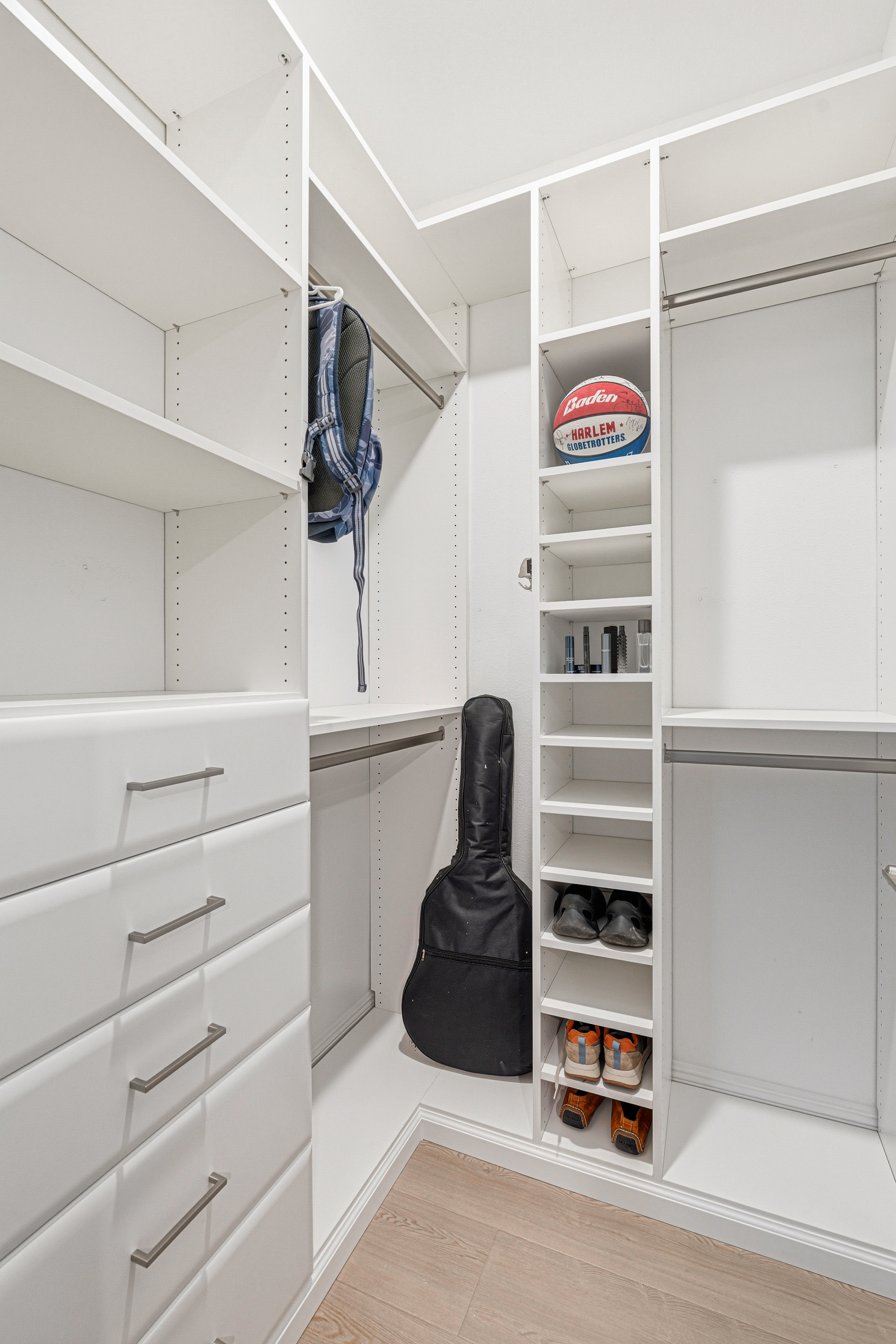 Walk-in closet corner with dedicated shoe cubbies, drawers, and sports equipment storage in Bradenton FL