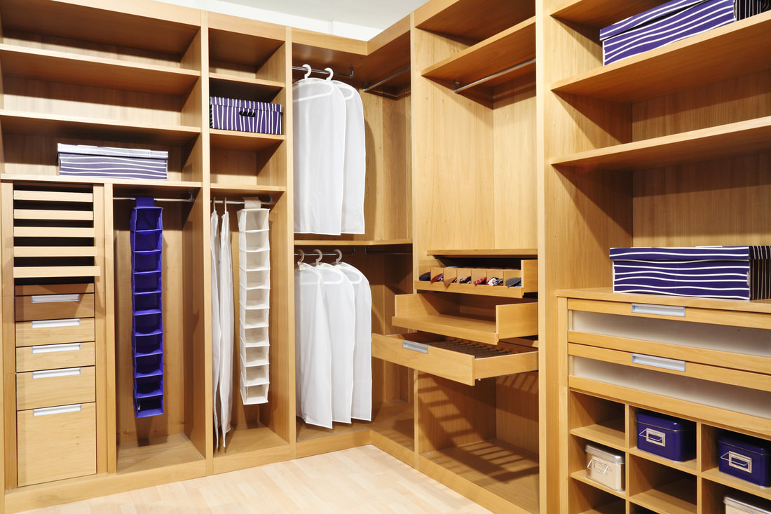 Walk-in custom closet with white laminate shelving and hanging rods in Sarasota FL